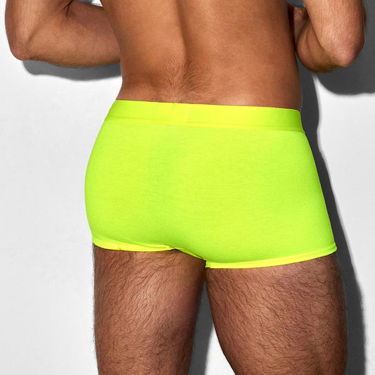 Person wearing bright green swim shorts on a plain background
