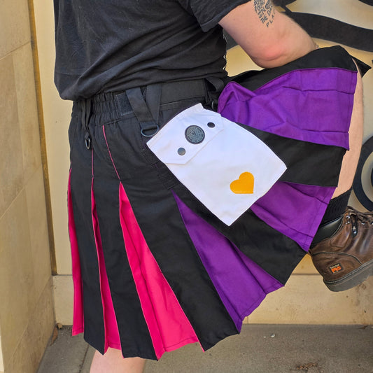 Person wearing a colorful kilt with a unique design, sitting on a bench.