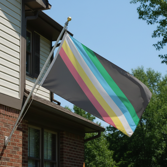 disability pride flag being flown from a flagpole attached to a house. The flag is charcoal with 5 diagonal stripes of green, blue, white, yellow, and red through the center