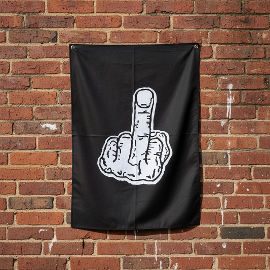 A black flag hanging on a red brick wall, featuring a white graphic of a hand making the middle finger gesture.