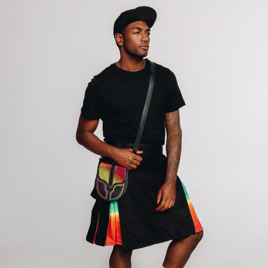 Person wearing a black t-shirt, black kilt with colorful accents, and a rainbow sporran on a white background