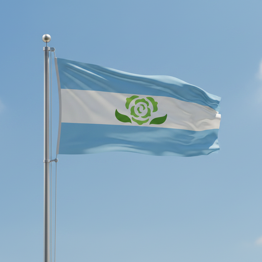 A light blue and white flag with a green rose emblem in the center, attached to a silver flagpole and waving against a clear blue sky.