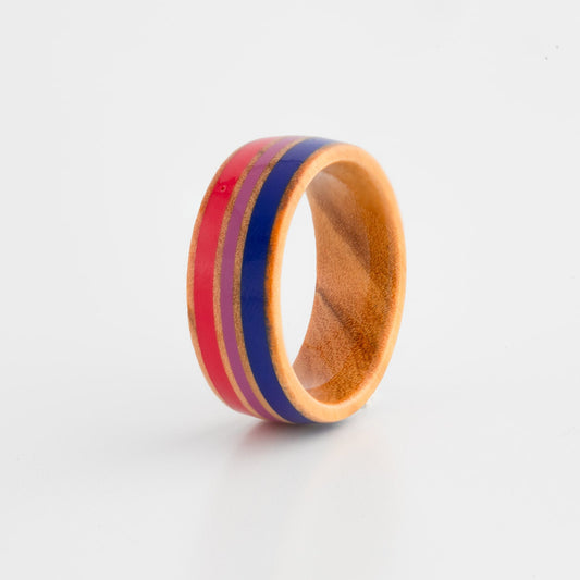 Wooden ring with bisexual pride flag inlay on a white background