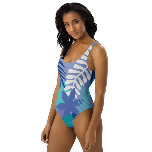 Woman wearing a blue and green floral one-piece swimsuit on a white background