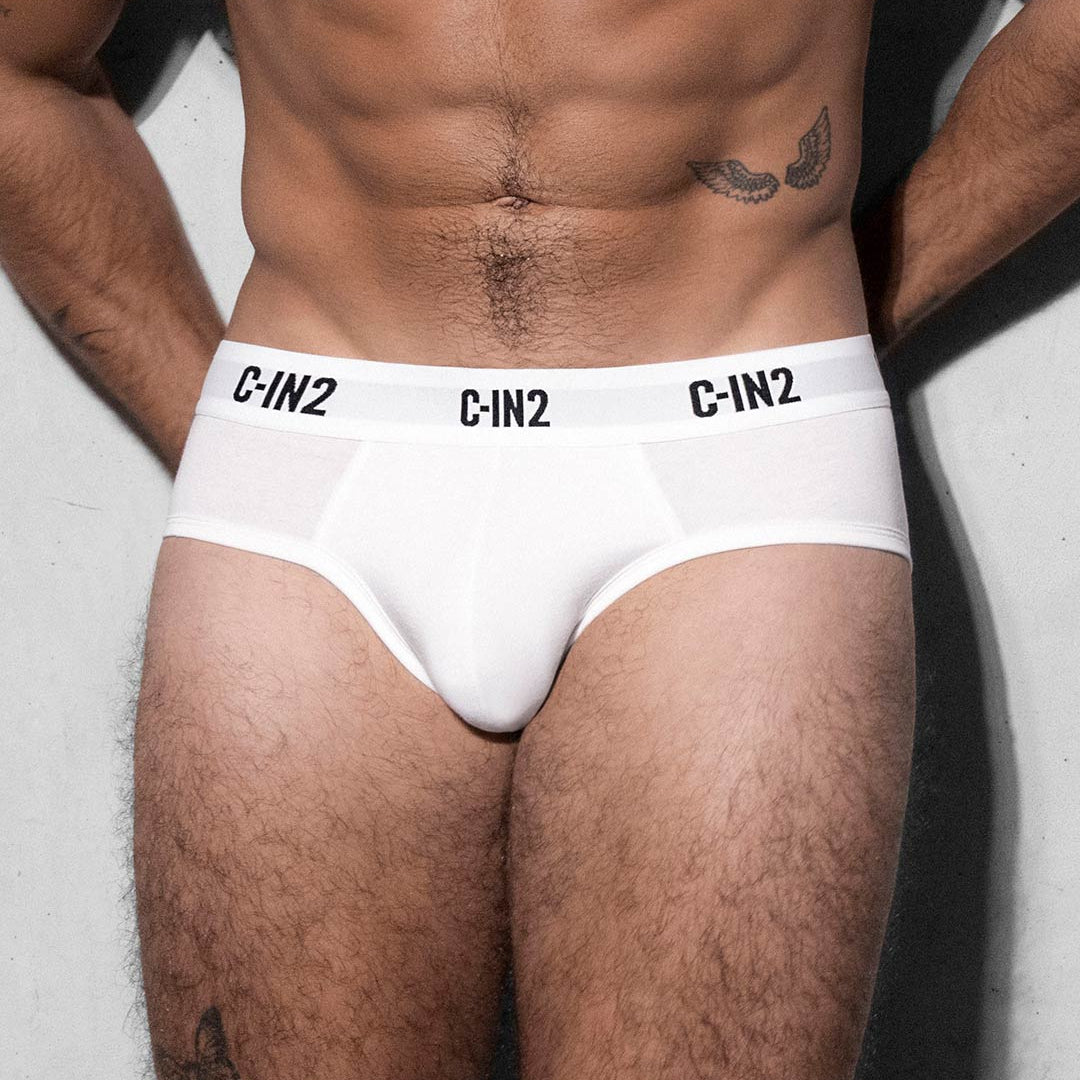 Person wearing white underwear with 'C-IN2' branding on a plain background
