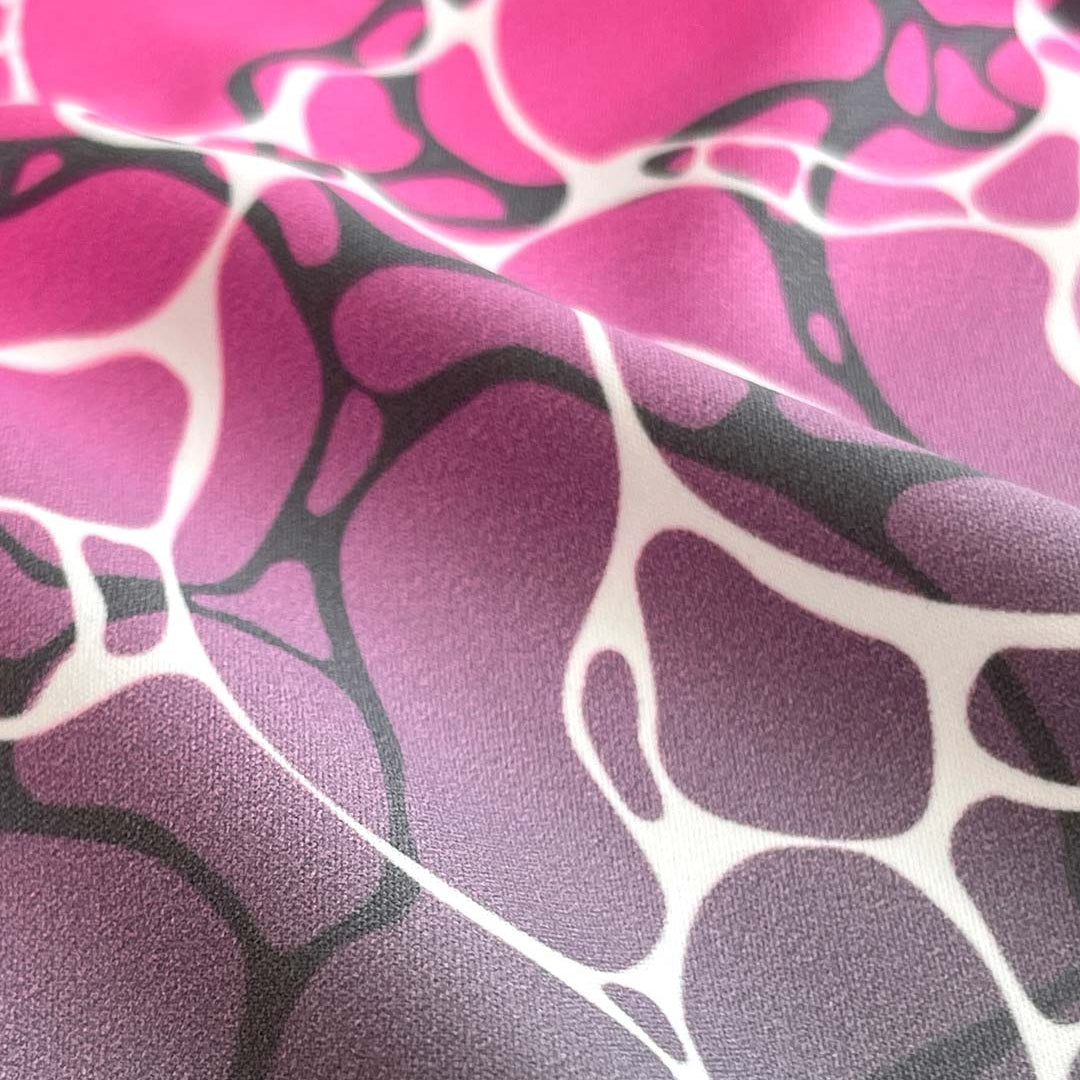 Close-up of fabric with pink, purple, and black abstract pattern