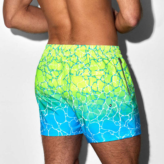 Person wearing a colorful swim shorts with a pattern on a white background