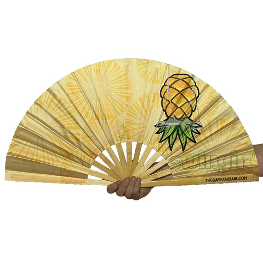 Handheld fan with upside-down pineapple swingers design on a white background