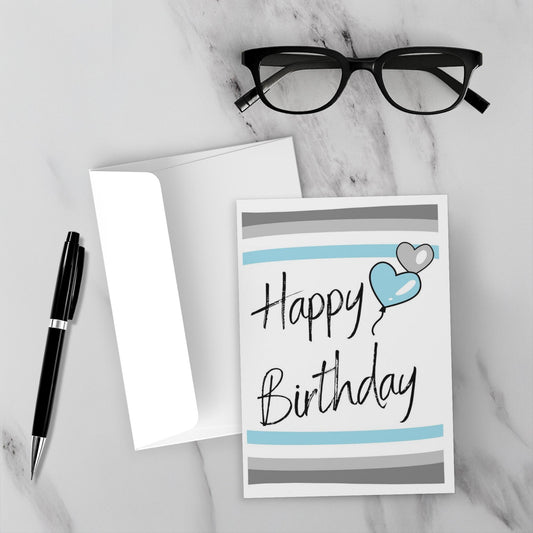 demiboy Birthday card with blue heart and gray stripes on a marble surface with glasses and pen.