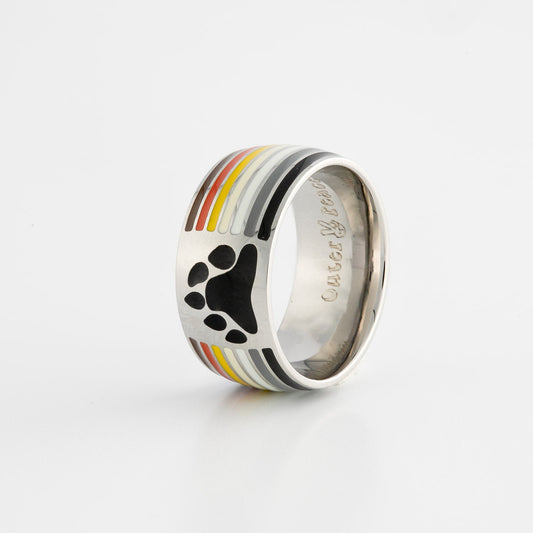 Silver ring with gay bear pride stripes and a black paw print design on a white background