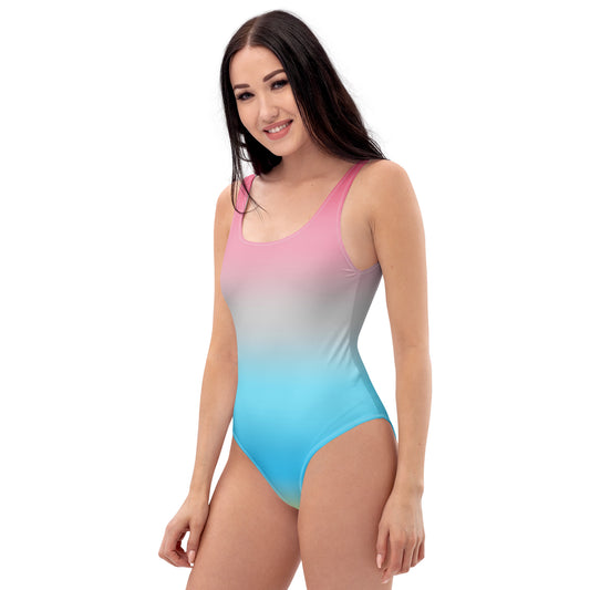 Woman wearing a genderflux pride flag gradient pink to blue swimsuit on a white background