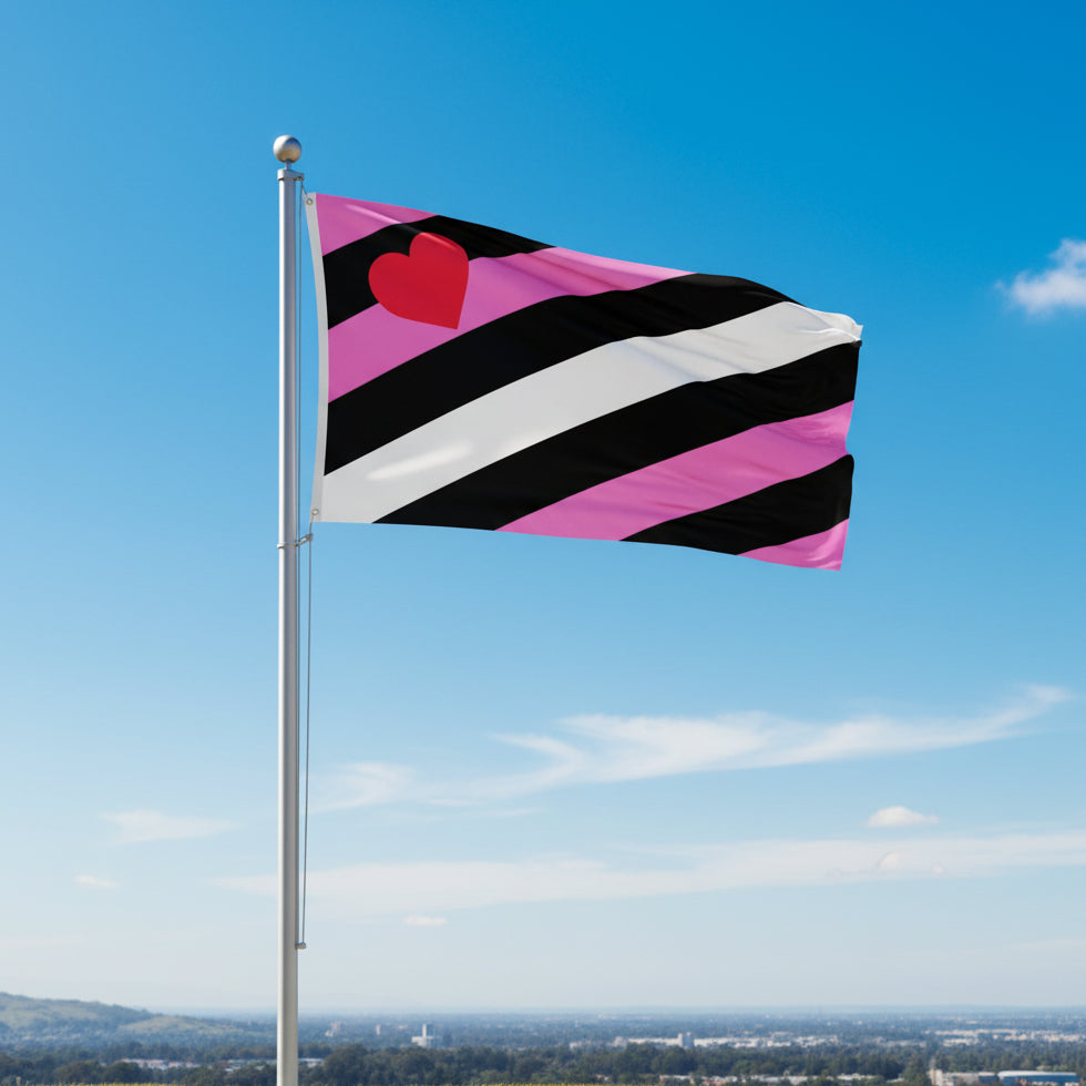 flag representing leather girl pride in pink, black, and white vertical stripes with a red heart in upper corner being flown from flagpole with blue sky in background