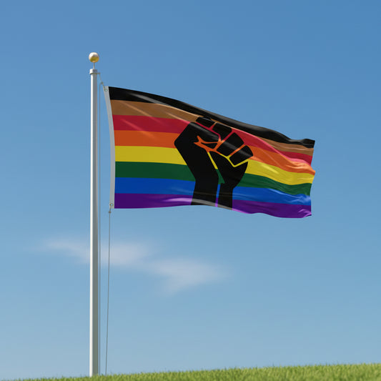 Philly pride flag with rainbow stripes and a black fist in the center flying from flagpole against a blue sky