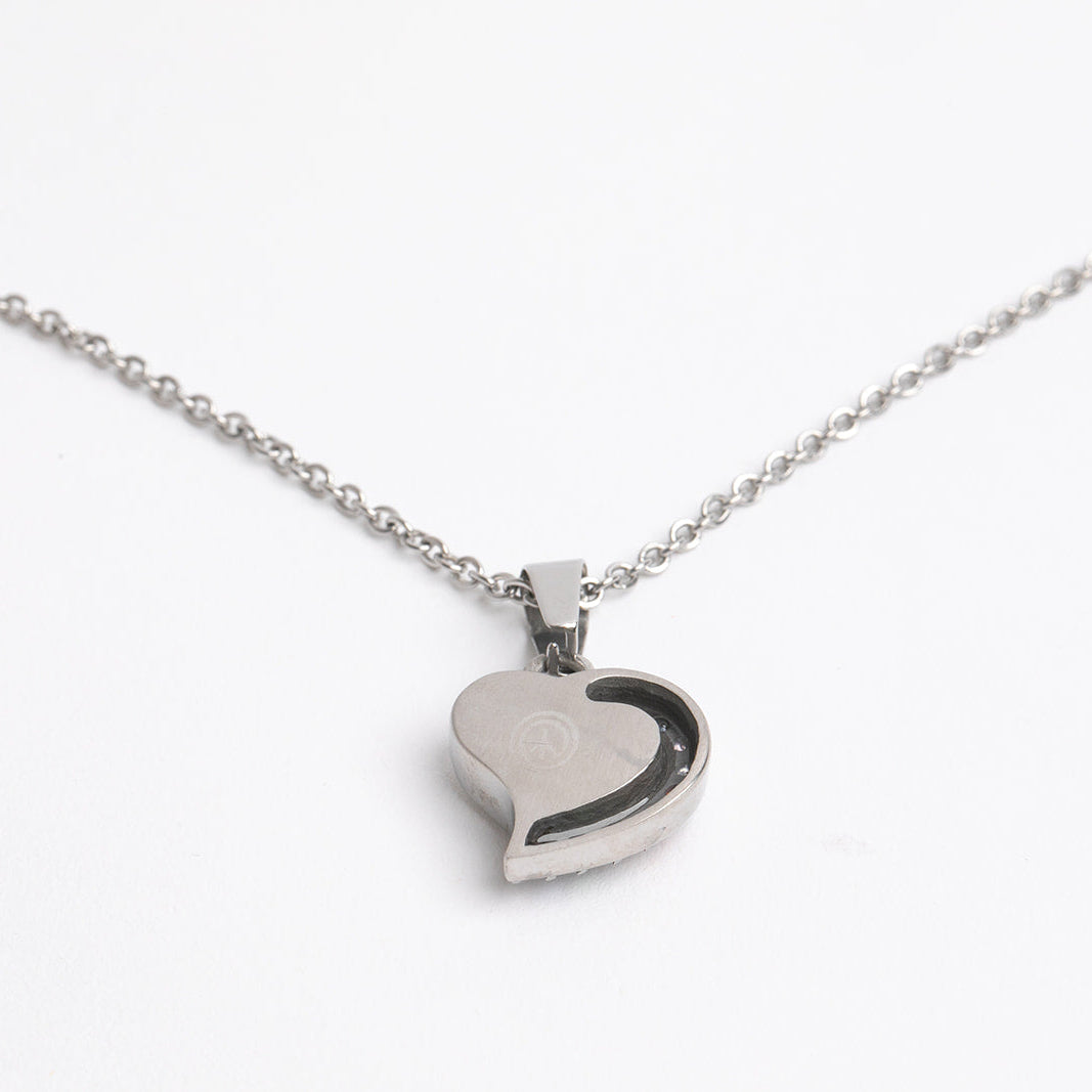 Heart-shaped pendant on a chain against a white background