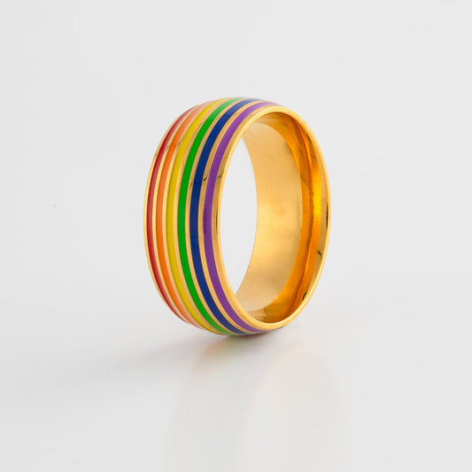 Ring with lgbt pride rainbow gold band on a light gray background