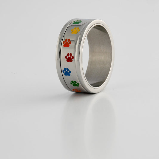 Silver ring with rainbow colored paw prints on a White background