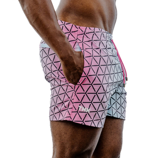 Pink and white geometric patterned shorts on a person against a white background