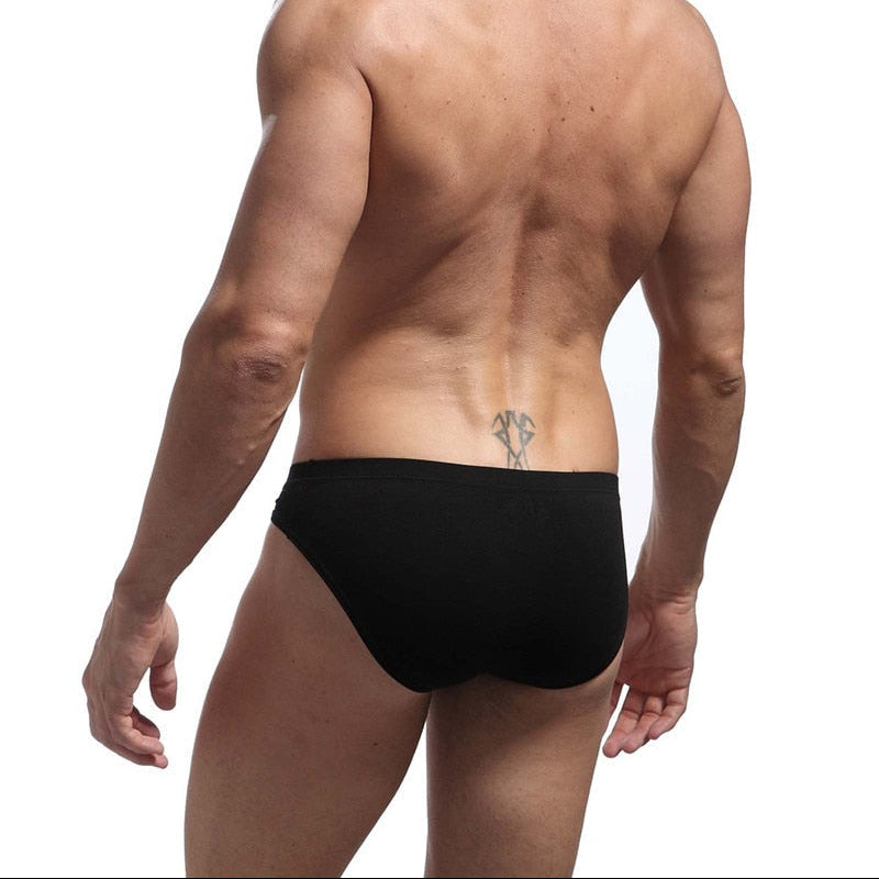 Man wearing a black swim brief on a white background