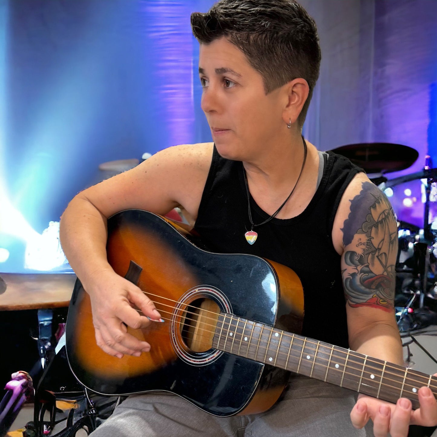 Person playing an acoustic guitar in a music studio setting