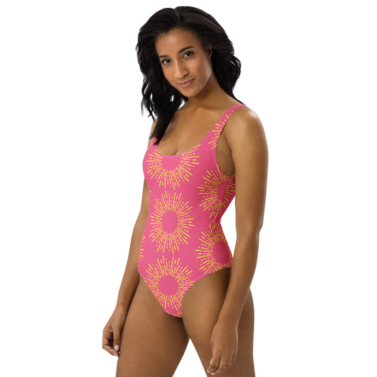 Woman wearing a pink swimsuit with yellow halo patterns on a white background