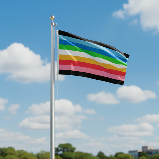 Queer pride flag with horizontal stripes in black, blues, green, white, yellow, and red and pink flying from a flagpole against a blue sky