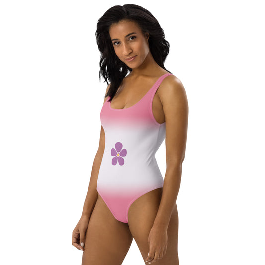 Woman wearing a sapphic pride pink and white swimsuit with a purple flower design on a white background