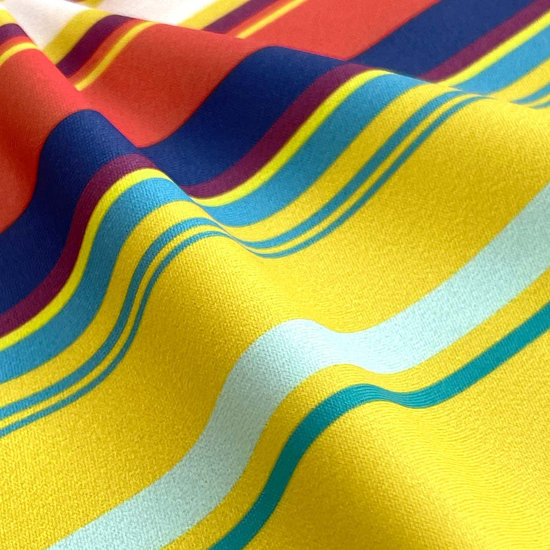 Close-up of colorful fabric with wavy pattern on yellow background