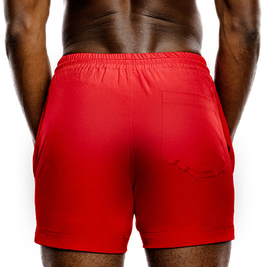 Red gym shorts worn by a person on a white background