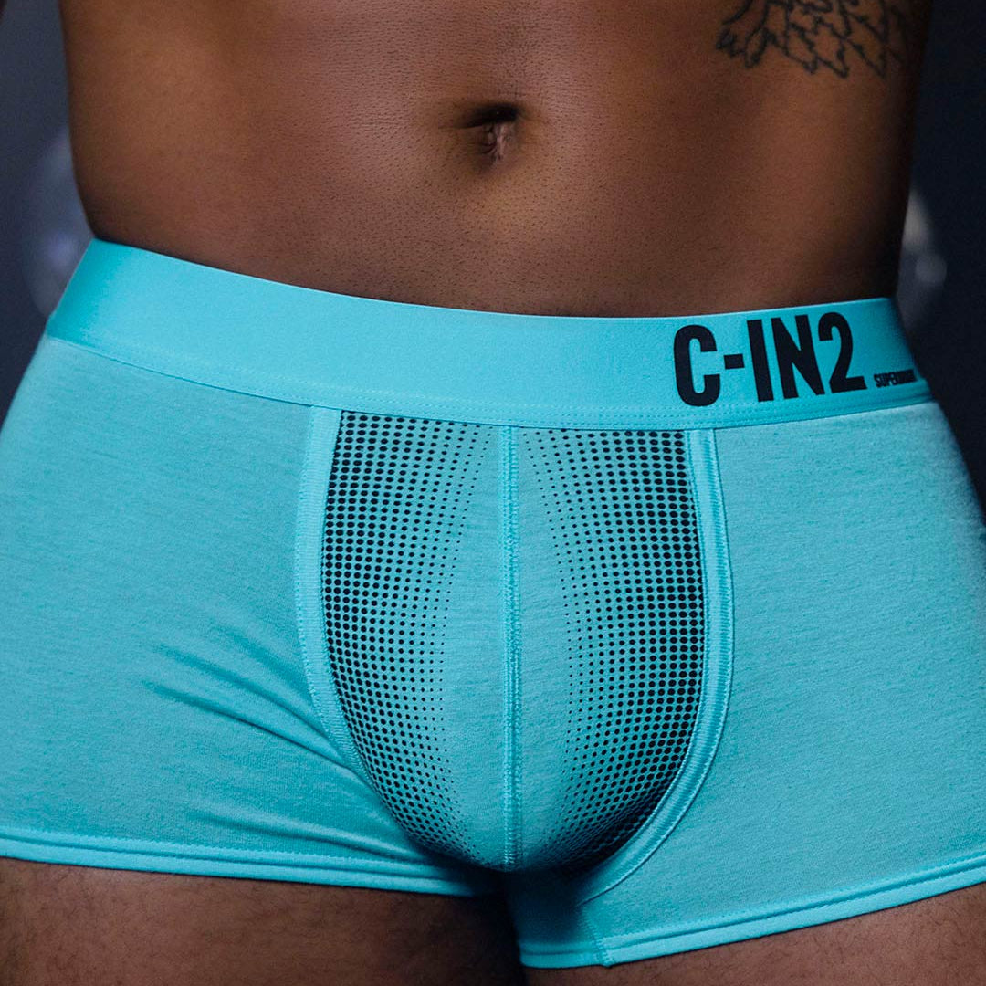 Turquoise men's underwear with 'C-IN2' brand label on a dark background