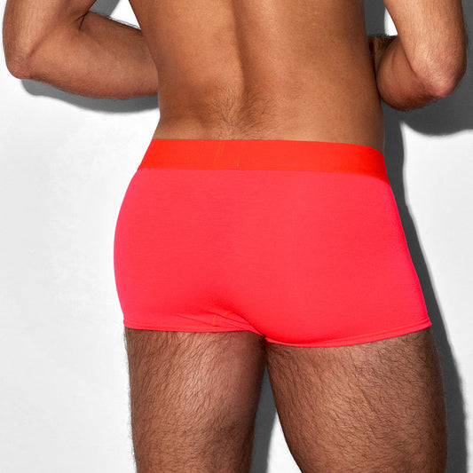 Person wearing bright red swim shorts on a plain background
