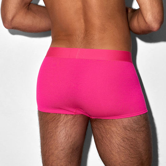 Person wearing bright pink underwear on a white background