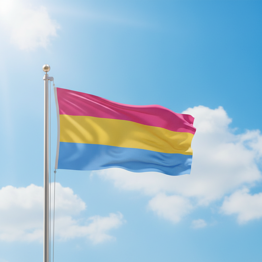 A pansexual pride flag with horizontal pink, yellow, and blue stripes waving on a silver flagpole against a bright blue sky with white clouds.