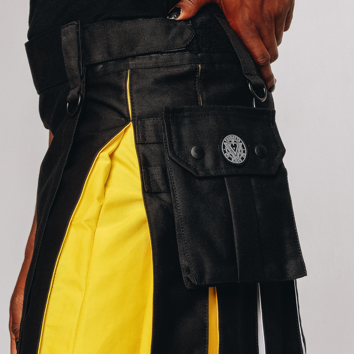 Black and yellow kilt with a brand logo on a plain background