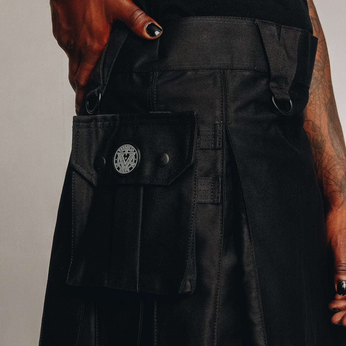 Black kilt with multiple pockets on a plain background