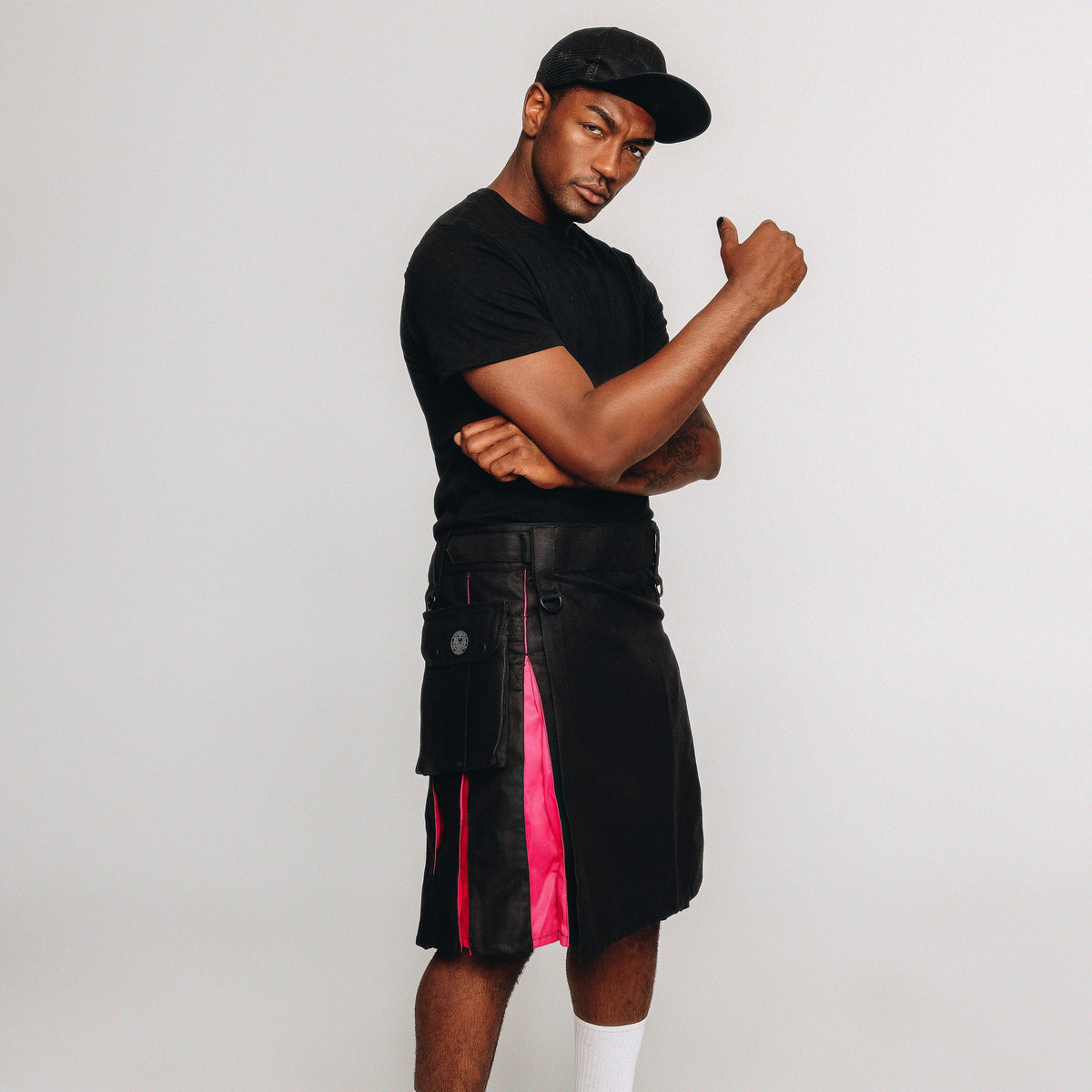 Man wearing a black kilt with rainbow accents on a white background