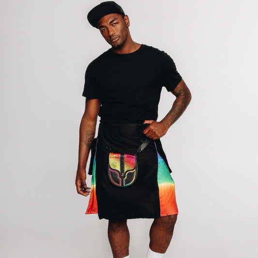 Person wearing a black t-shirt and black kilt with rainbow inserts with a sporran against a white background