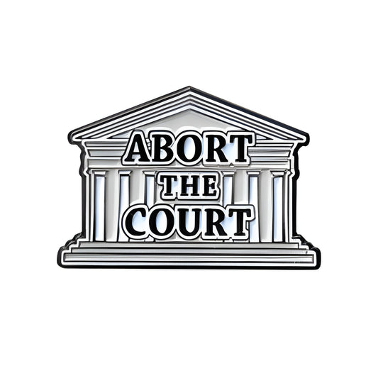 Stylized courthouse lapel pin with 'ABORT THE COURT' text on a white background
