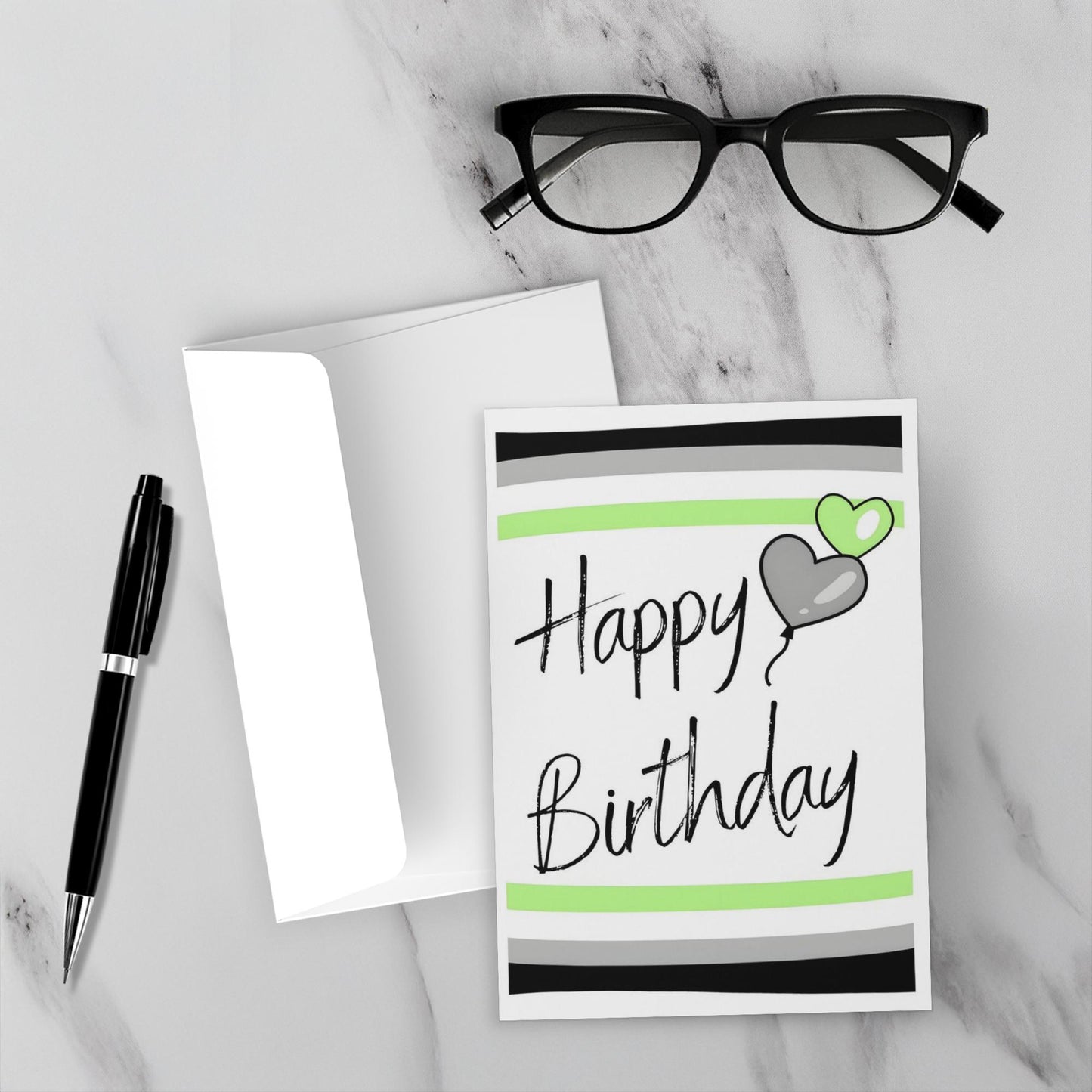 agender Birthday card with heart and balloon design on a marble surface with glasses and pen.