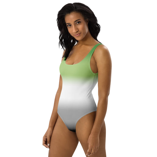 Woman wearing a green to white gradient aromantic pride swimsuit on a white background
