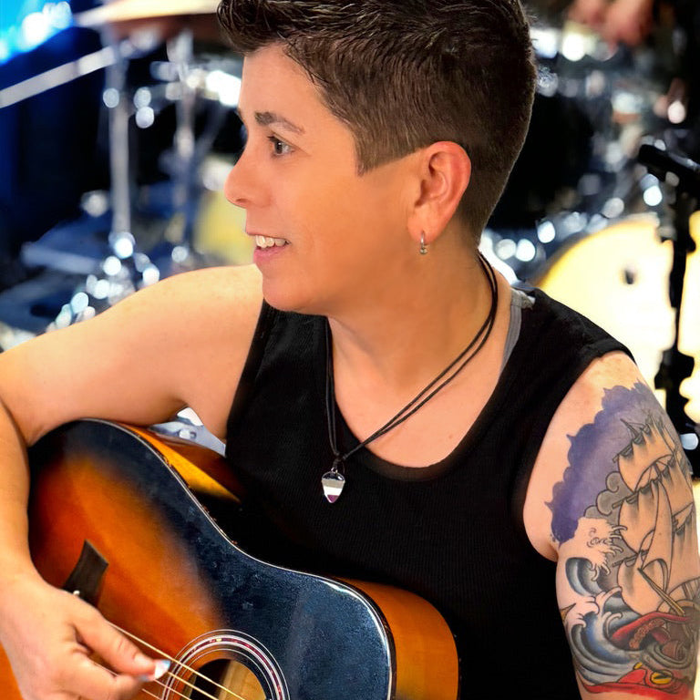 Person playing an acoustic guitar in a music studio setting