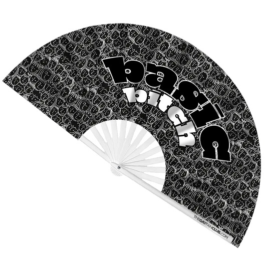 Black and white patterned hand fan with text 'Basic Bitch' and visible brand name on a white background