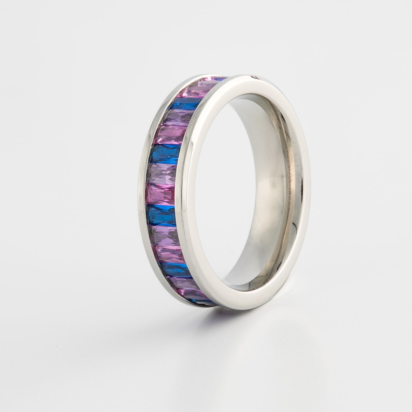 Silver ring with bi pride flag color gemstones on a white background