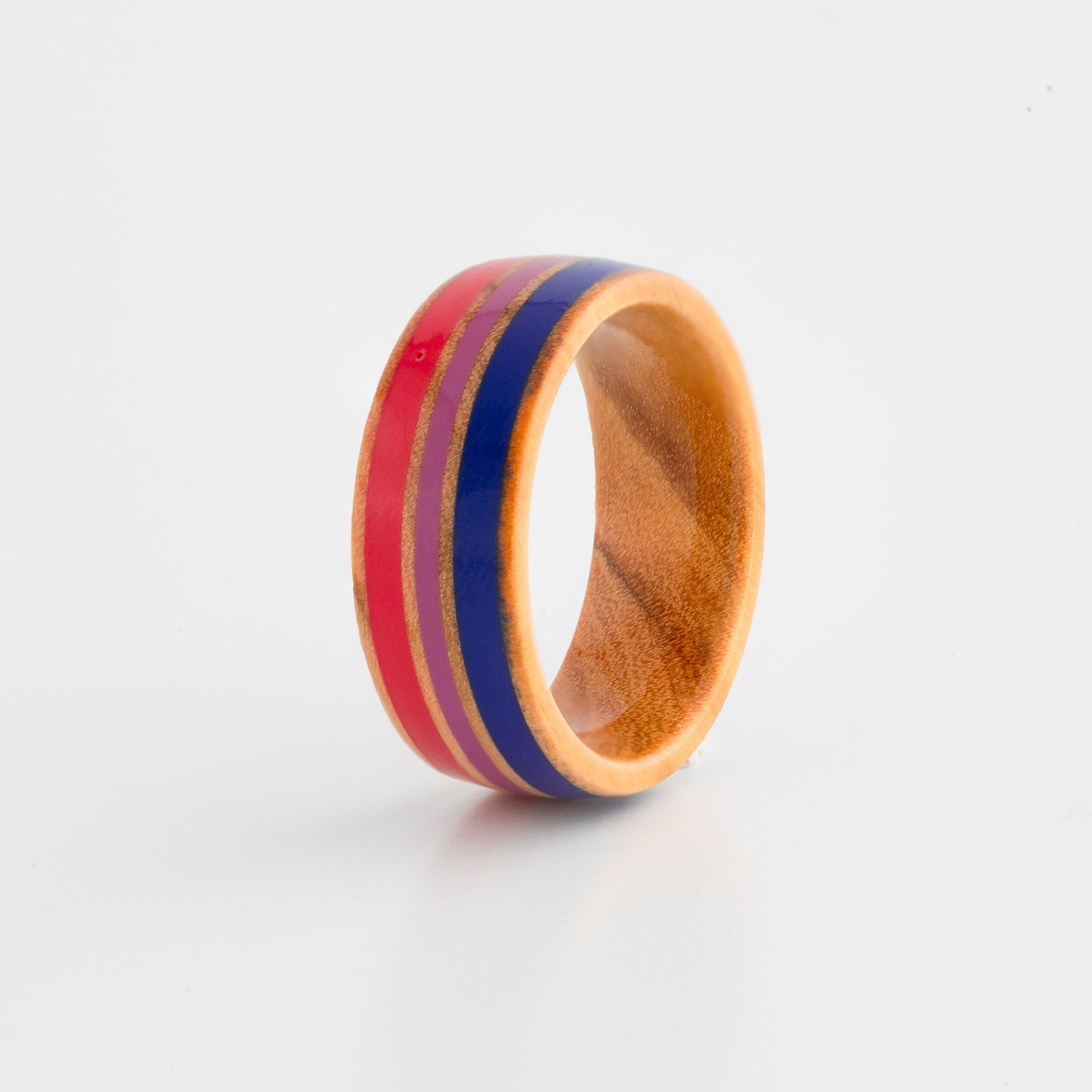 Wooden ring with bisexual pride flag inlay on a white background
