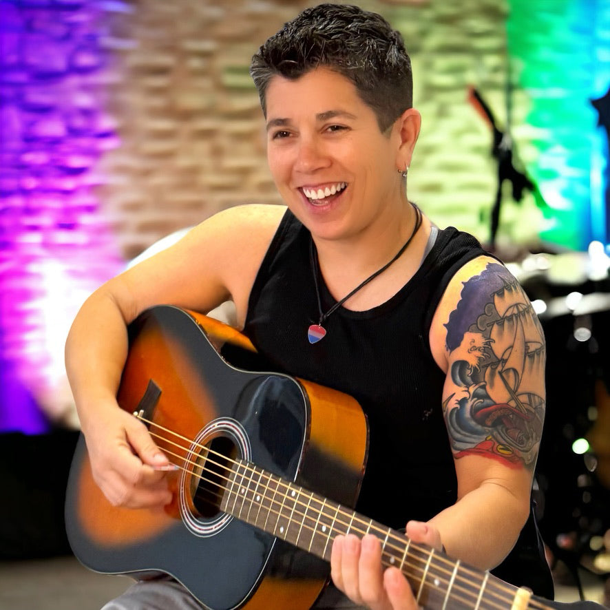Person playing an acoustic guitar with a colorful background