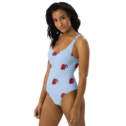 Woman wearing a light blue swimsuit with red heart patterns on a white background