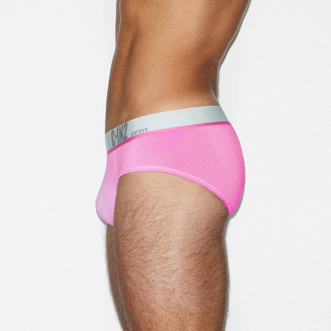Person wearing pink underwear with a visible brand logo on a white background