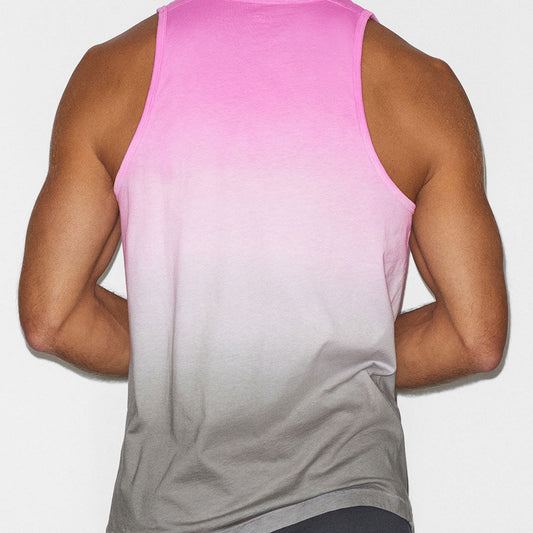 Person wearing a pink to gray gradient tank top on a plain background
