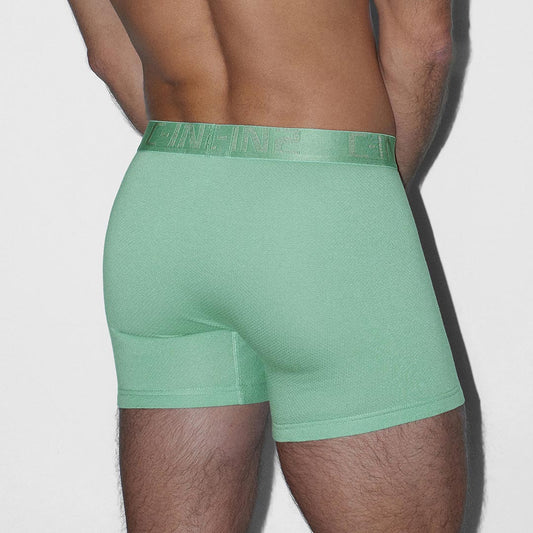 A man's lower back and thighs are shown wearing mint green boxer briefs against a light gray studio background.