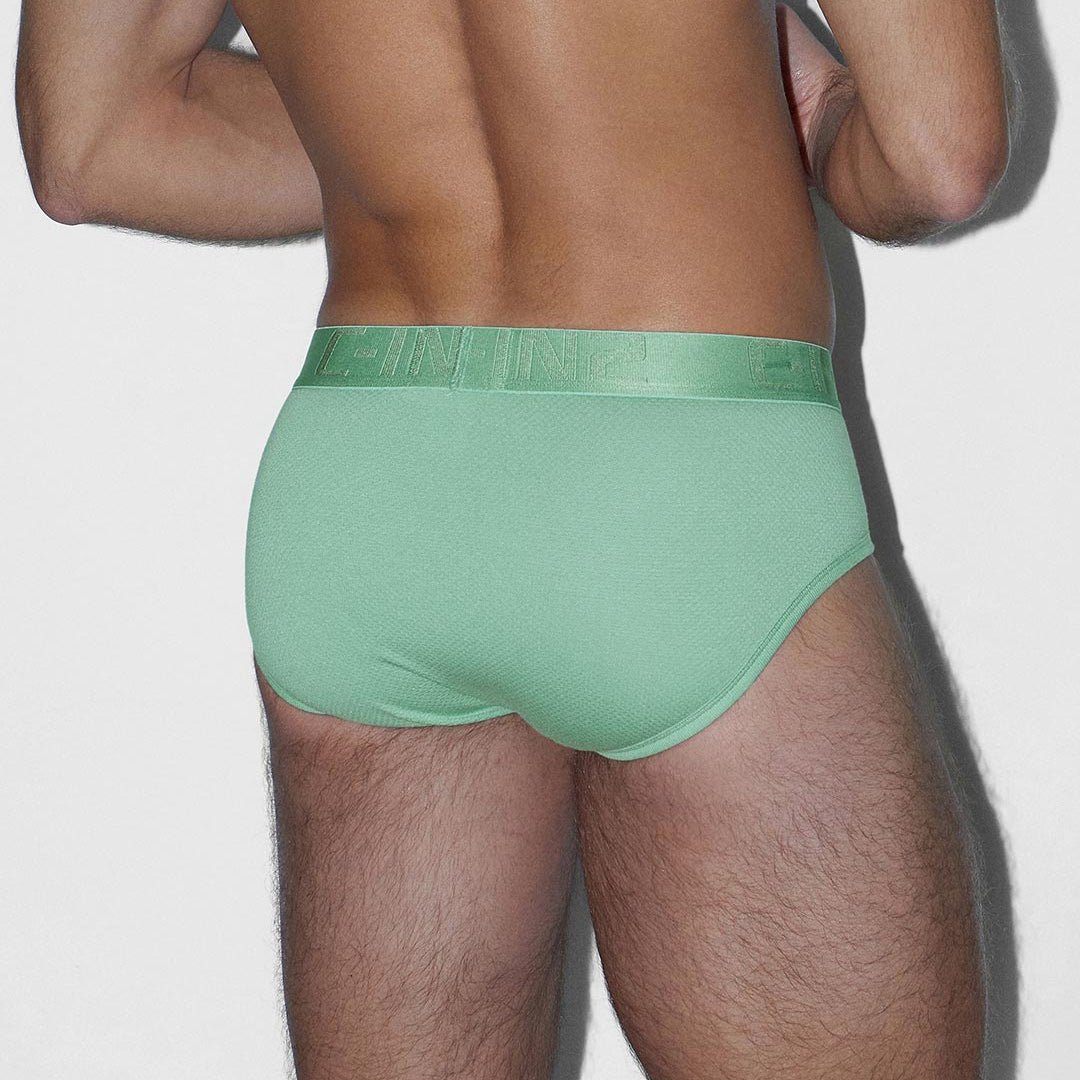 Person wearing green underwear on a plain background