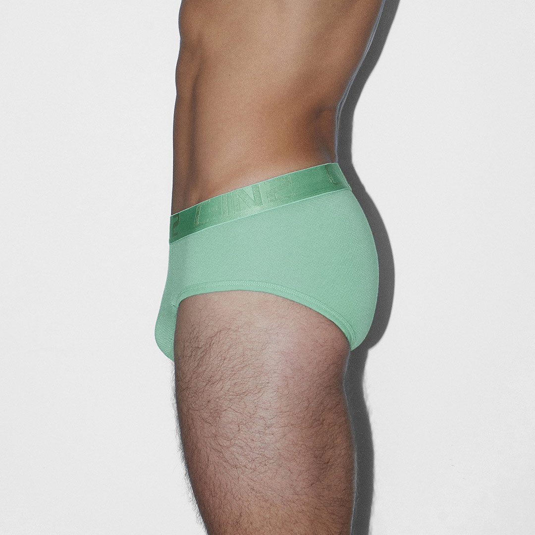 Green underwear worn by a person on a white background